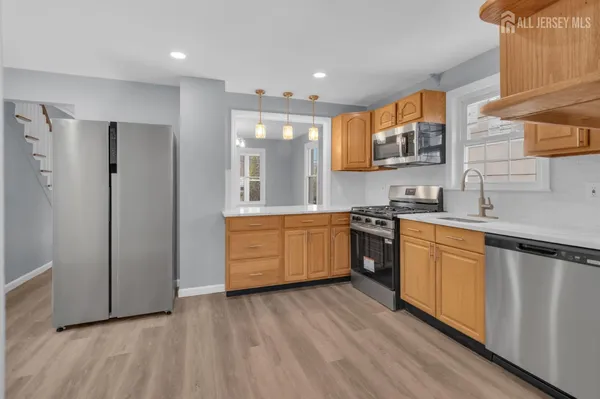 a kitchen with stainless steel appliances white cabinets and wooden floors