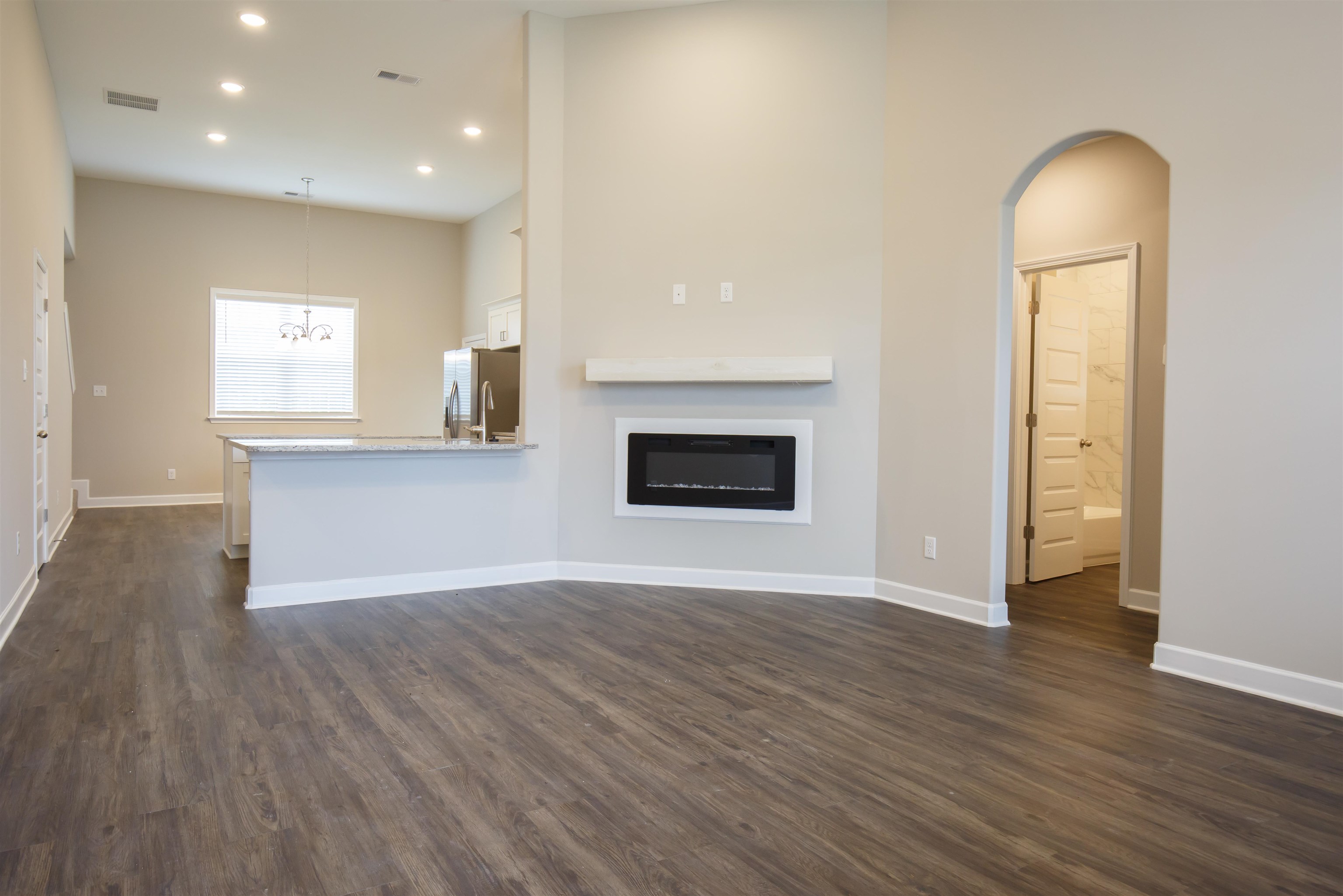 8763 Shipp Road Millington, TN 38053 - Photo 2 of 9 Unfurnished living room with dark wood-style flooring, a glass covered fireplace, baseboards, visible vents, and recessed lighting