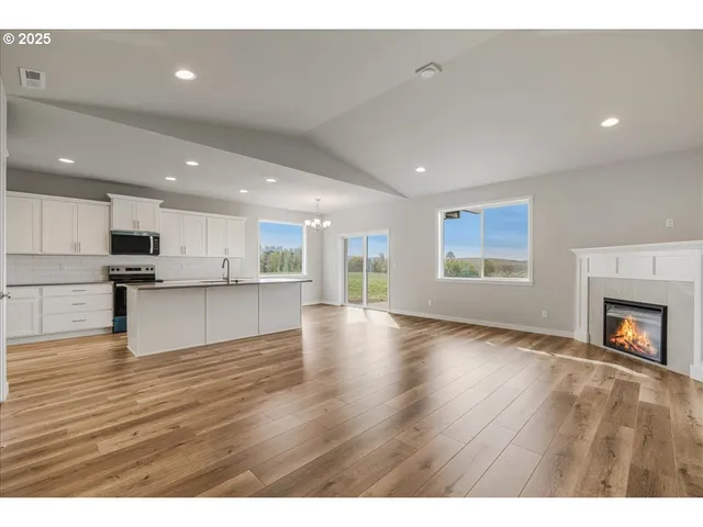 a view of empty room with wooden floor and fireplace