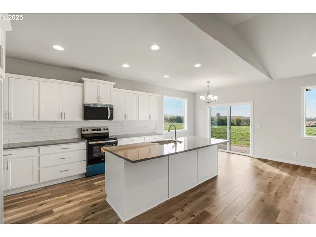 a kitchen with kitchen island a sink stainless steel appliances and white cabinets