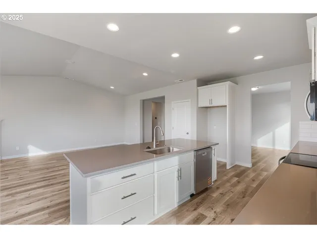 a kitchen with white cabinets a sink and appliances