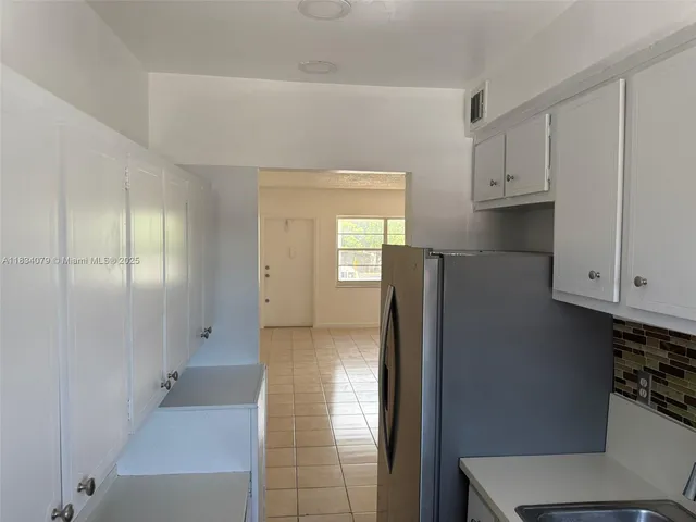 a view of hallway with cabinets and stairs