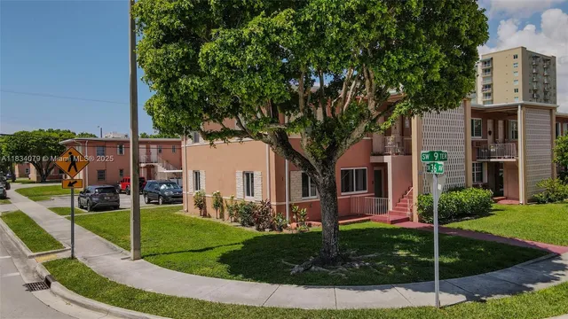 a tree in front of a white house