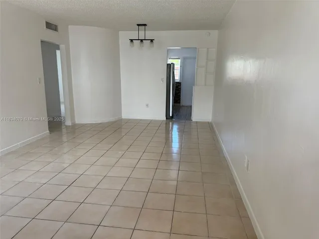 a view of hallway with a window and a refrigerator