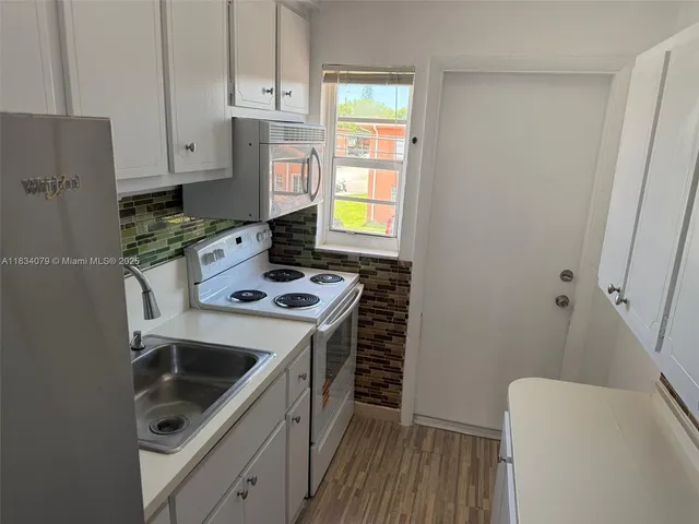 a kitchen with stainless steel appliances a stove a sink and a refrigerator