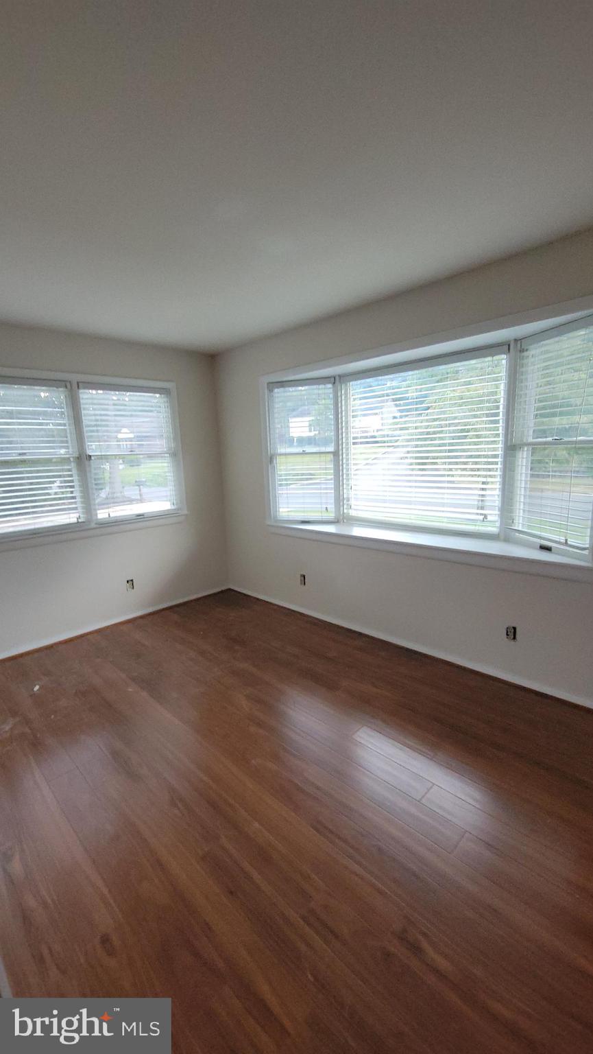 569 Lakeside Avenue Woodbury, NJ 08096 - Photo 3 of 9 an empty room with wooden floor and windows