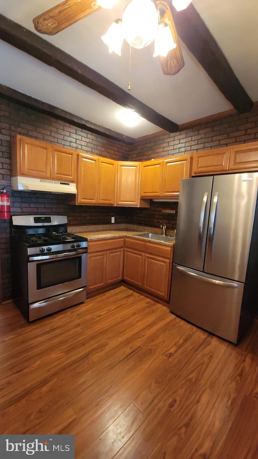 569 Lakeside Avenue Woodbury, NJ 08096 - Photo 4 of 9 a large kitchen with wooden floors and stainless steel appliances
