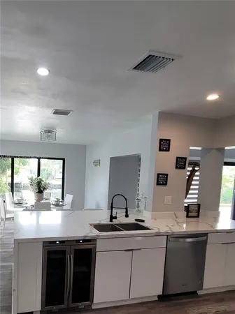 a kitchen with stainless steel appliances granite countertop a sink and a stove next to a window
