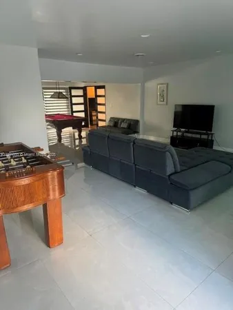 a living room with furniture a flat screen tv and a window
