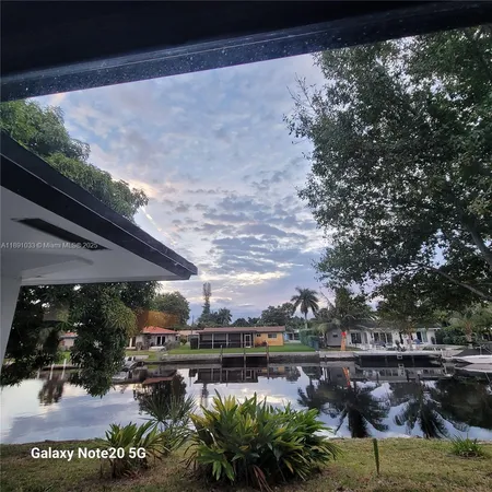 a view of a swimming pool with outdoor seating and a garden