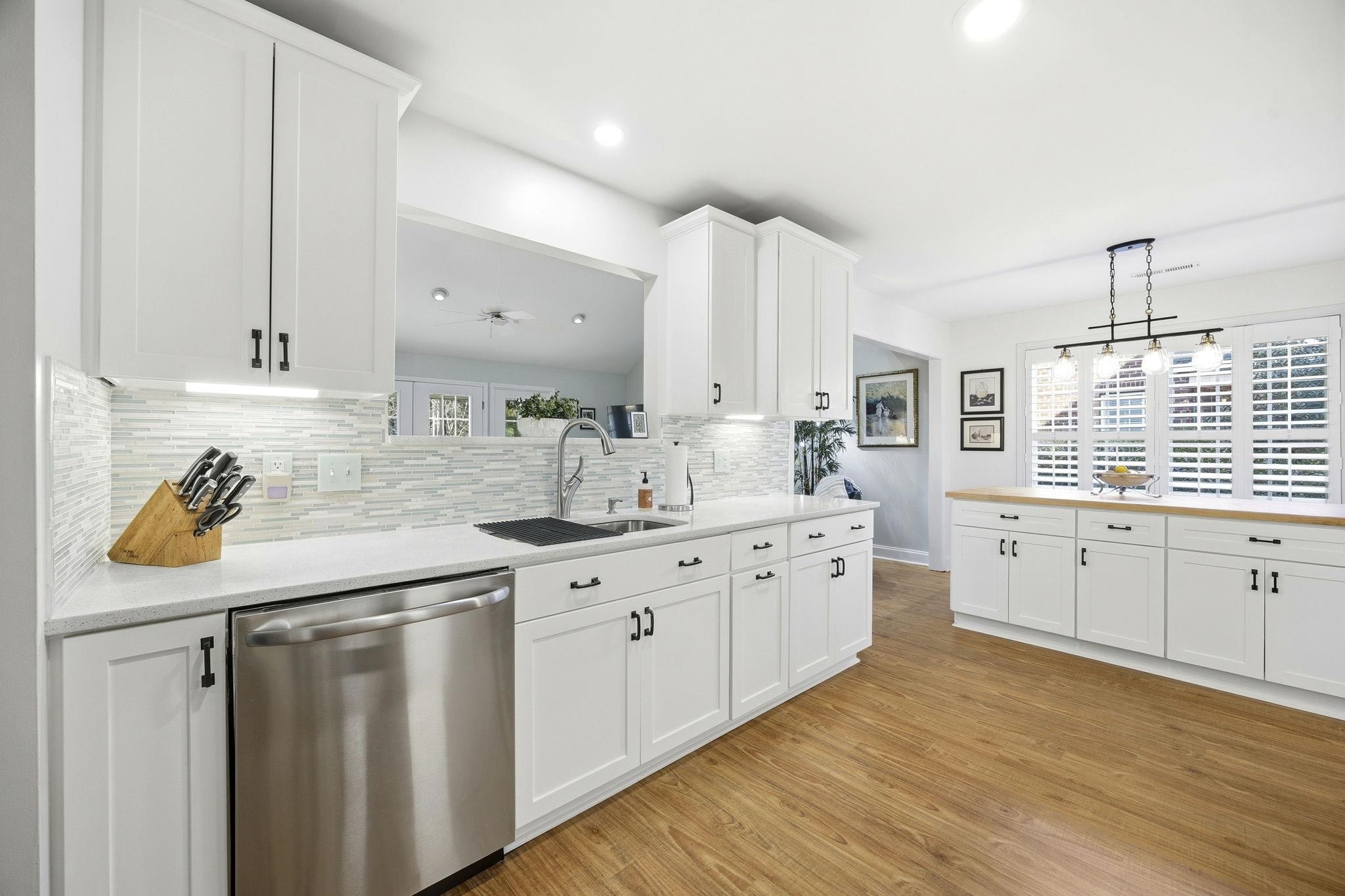 1301 Regent Terrace North Surfside Beach, SC 29575 - Photo 14 of 40 Kitchen with white cabinetry, stainless steel dishwasher, pendant lighting, tasteful backsplash, and light wood finished floors