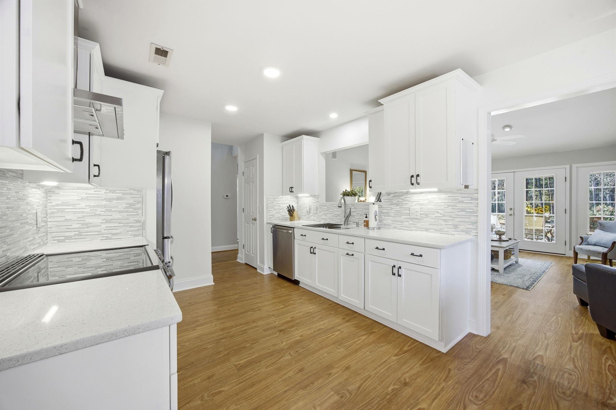 1301 Regent Terrace North Surfside Beach, SC 29575 - Photo 16 of 40 Kitchen with white cabinetry, light stone countertops, light wood finished floors, backsplash, and recessed lighting