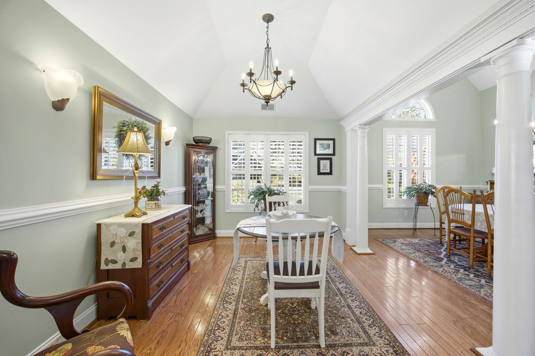 1301 Regent Terrace North Surfside Beach, SC 29575 - Photo 17 of 40 Dining room featuring a chandelier, light wood-style flooring, vaulted ceiling, and decorative columns