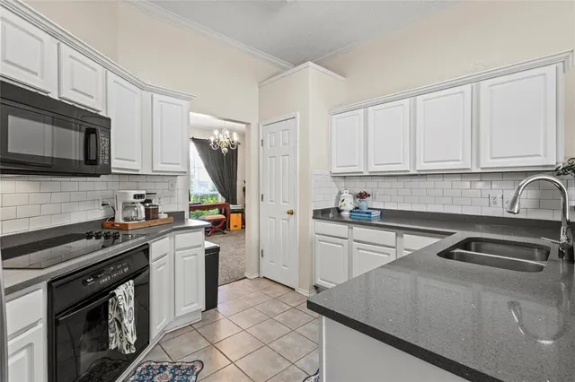 a kitchen with stainless steel appliances granite countertop a sink a stove a refrigerator a washer dryer and cabinets