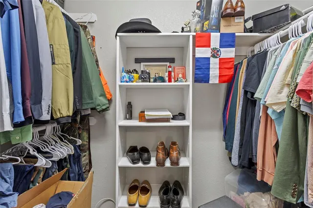 a view of walk in closet with clothes and shoes
