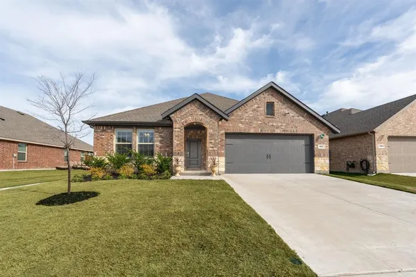 a front view of a house with yard and garage
