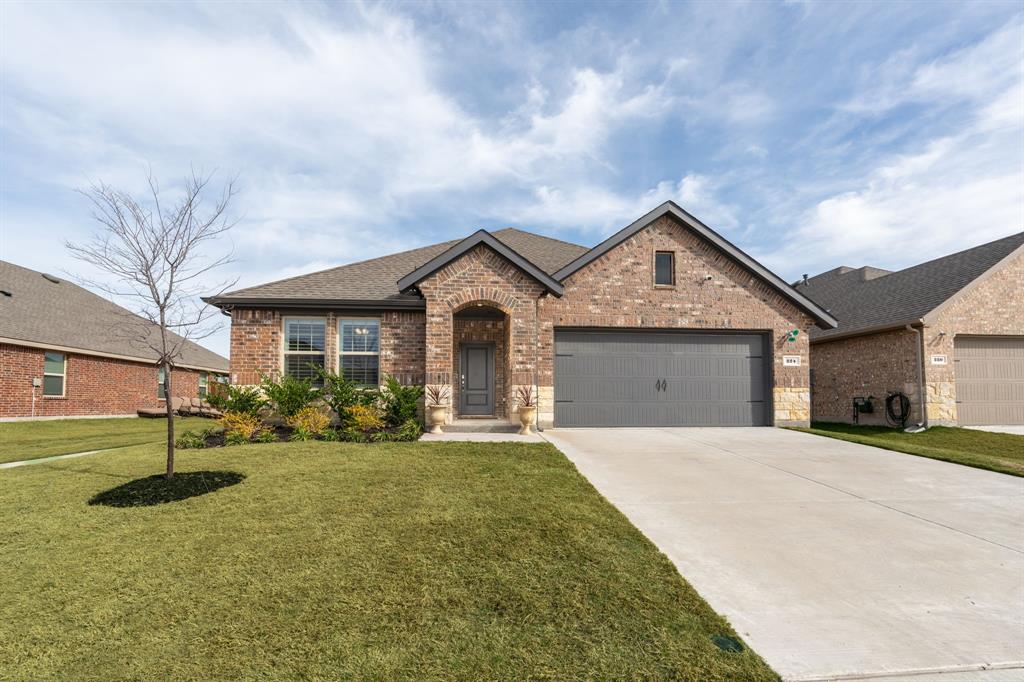 a front view of a house with yard and garage