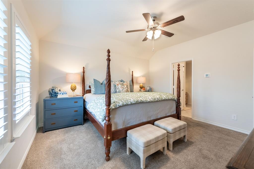 224 Wakefield Road Fate, TX 75189 - Photo 15 of 30 a bedroom with a bed and a chandelier