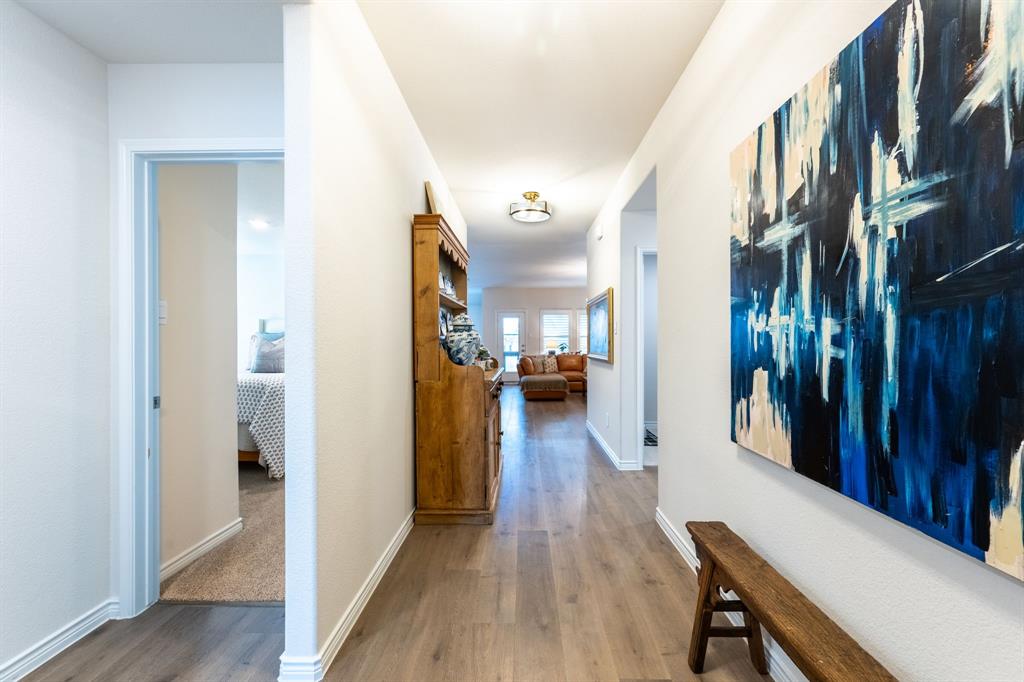 224 Wakefield Road Fate, TX 75189 - Photo 5 of 30 a view of a hallway with wooden floor and a living room