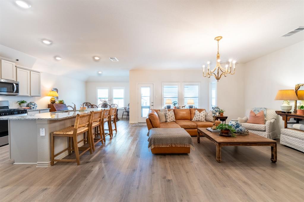 224 Wakefield Road Fate, TX 75189 - Photo 6 of 30 a living room with fireplace furniture and a chandelier