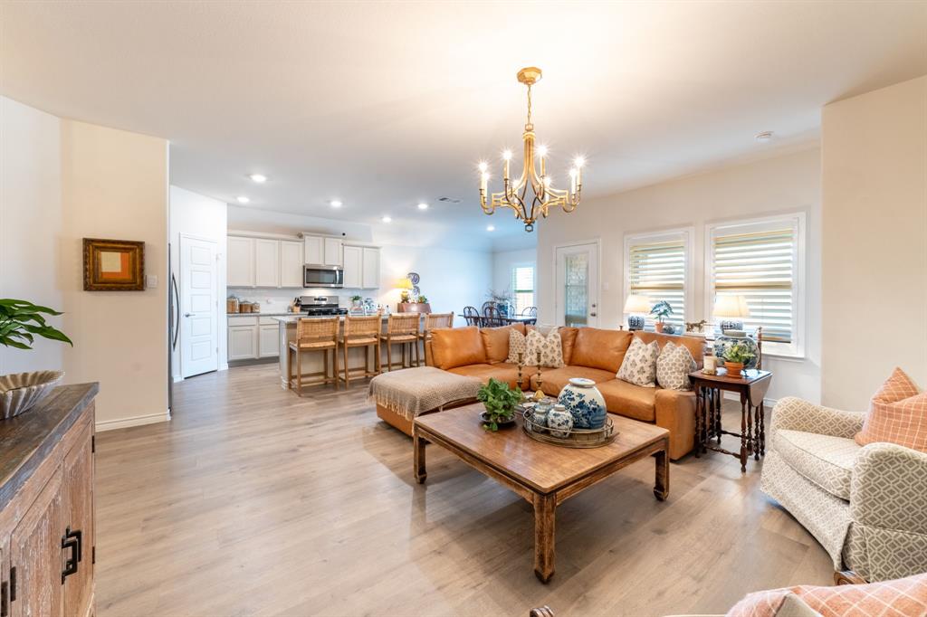 224 Wakefield Road Fate, TX 75189 - Photo 8 of 30 a living room with furniture kitchen view and a chandelier