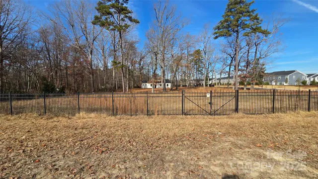 a view of backyard with wooden fence