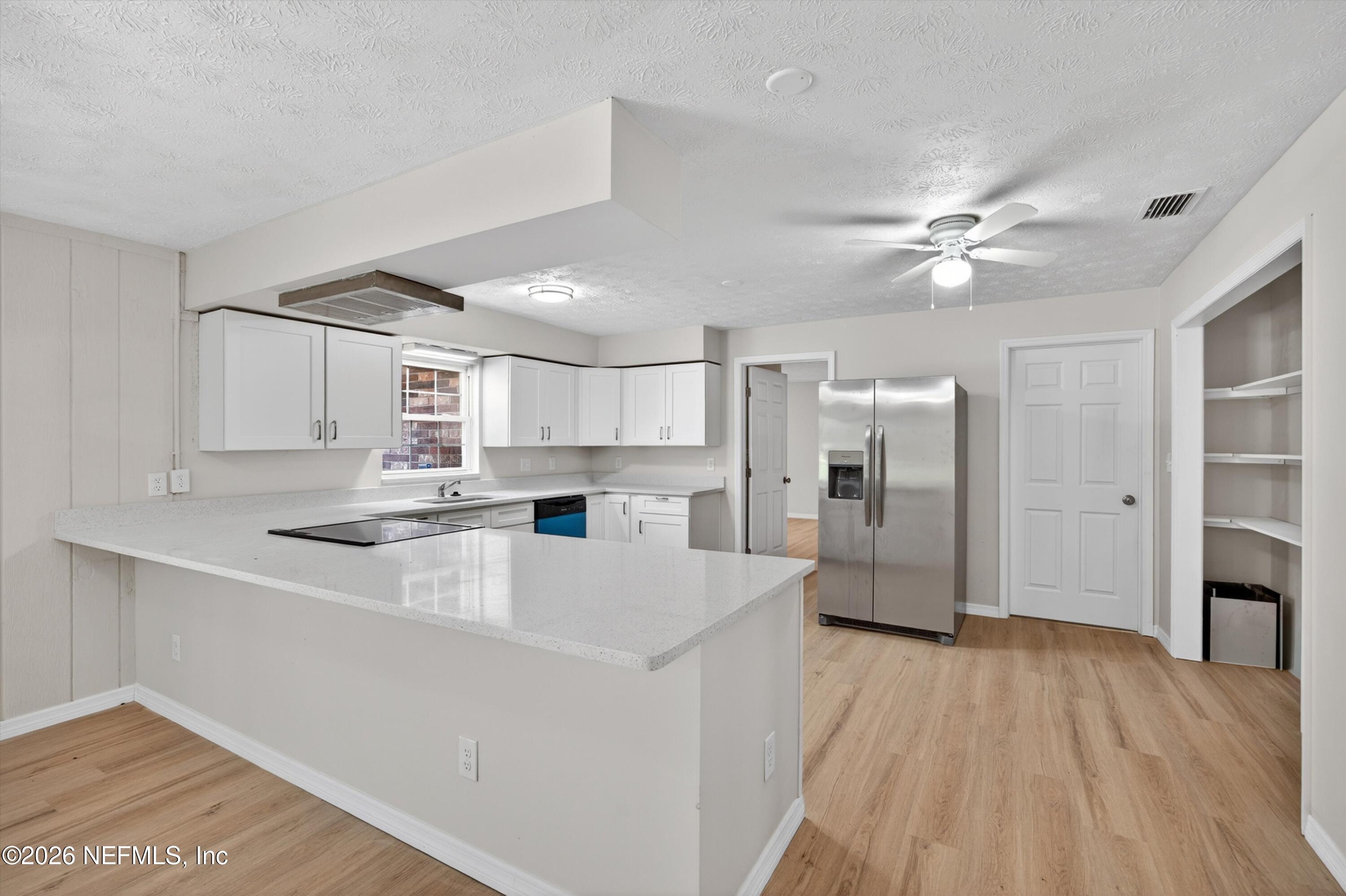 6894 Ridge Street Keystone Heights, FL 32656 - Photo 16 of 40 a large white kitchen with a stove a refrigerator a sink dishwasher with a dining table and chairs