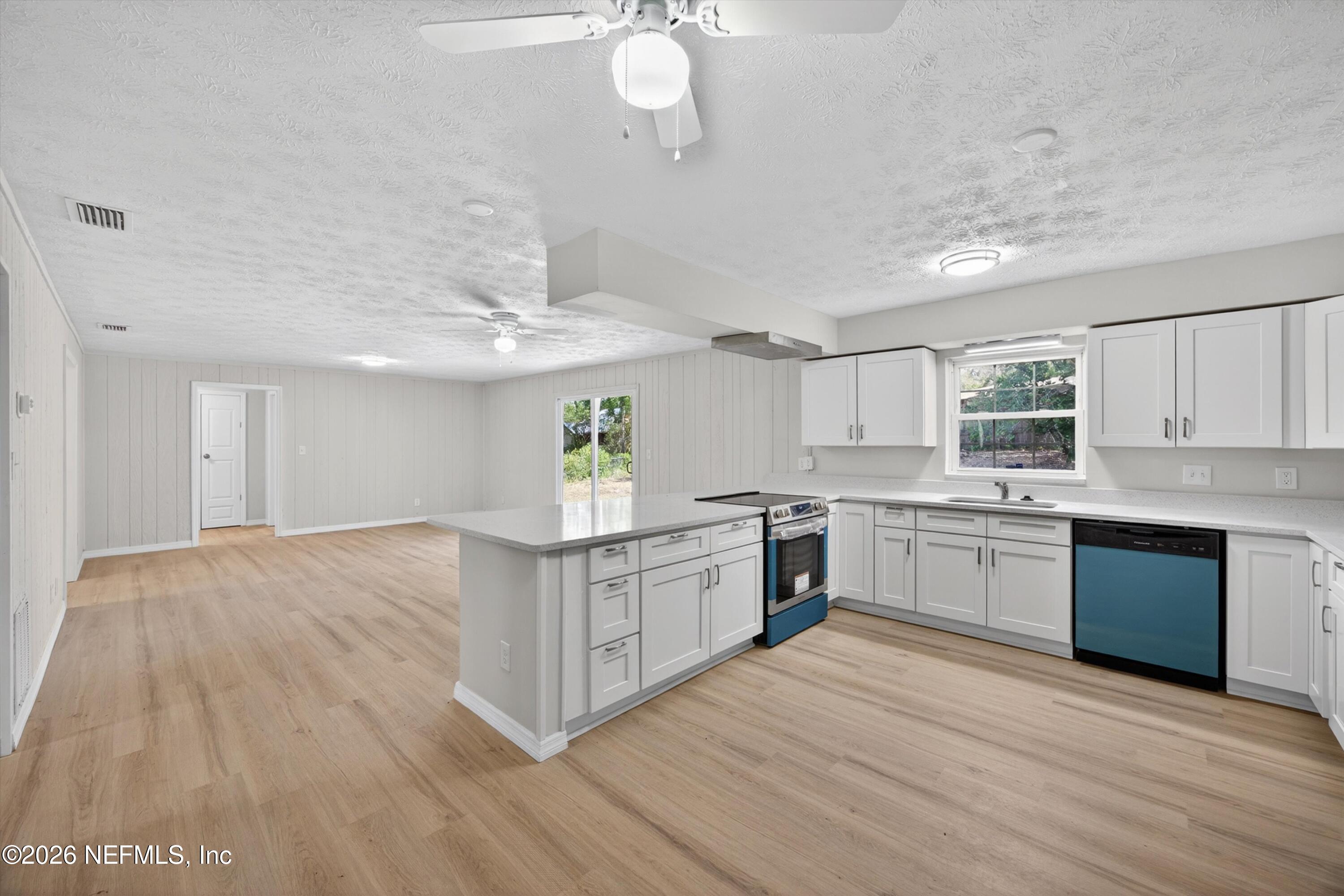 6894 Ridge Street Keystone Heights, FL 32656 - Photo 18 of 40 a kitchen with stainless steel appliances granite countertop a sink cabinets and wooden floor