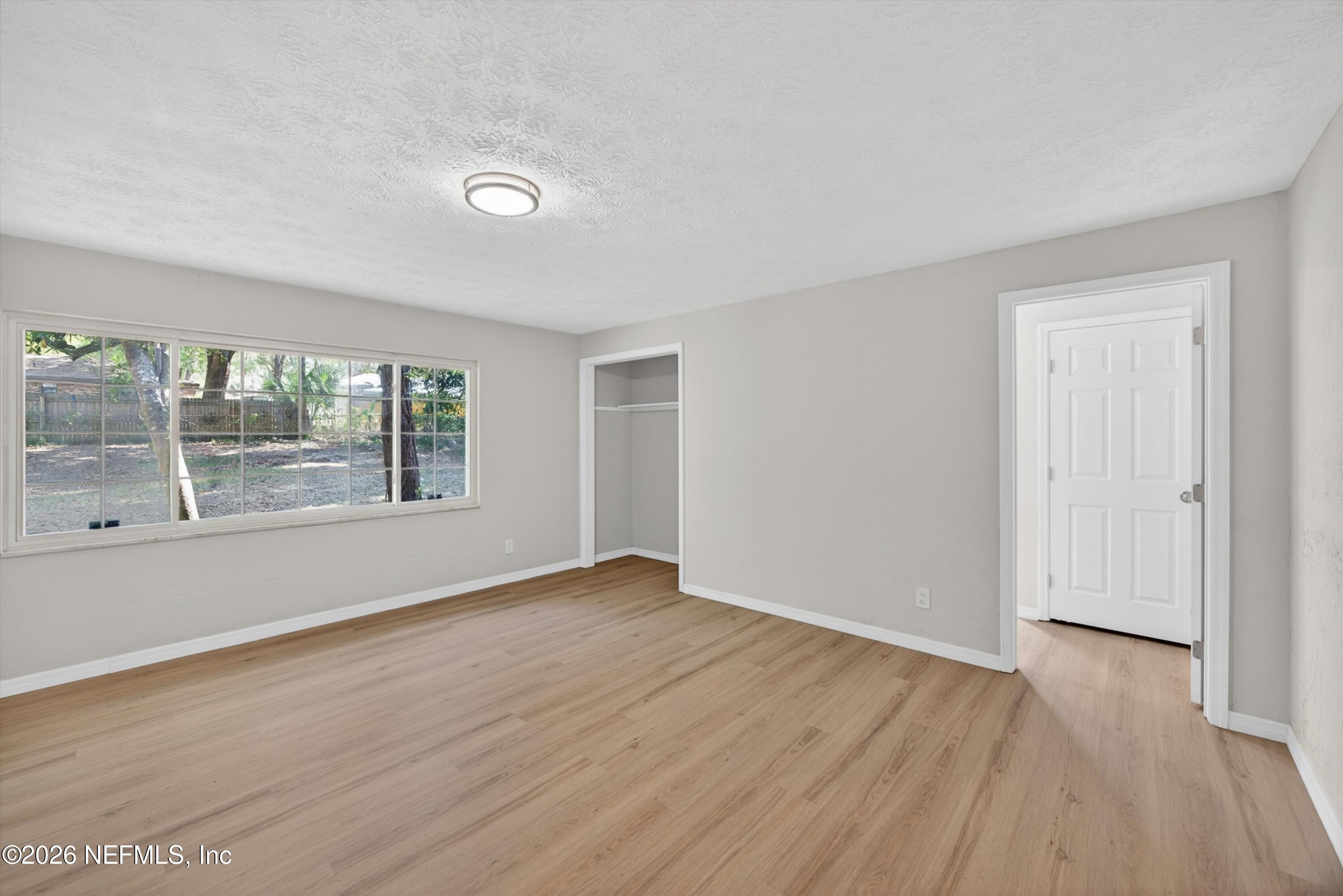 6894 Ridge Street Keystone Heights, FL 32656 - Photo 20 of 40 a view of an empty room with wooden floor and a window