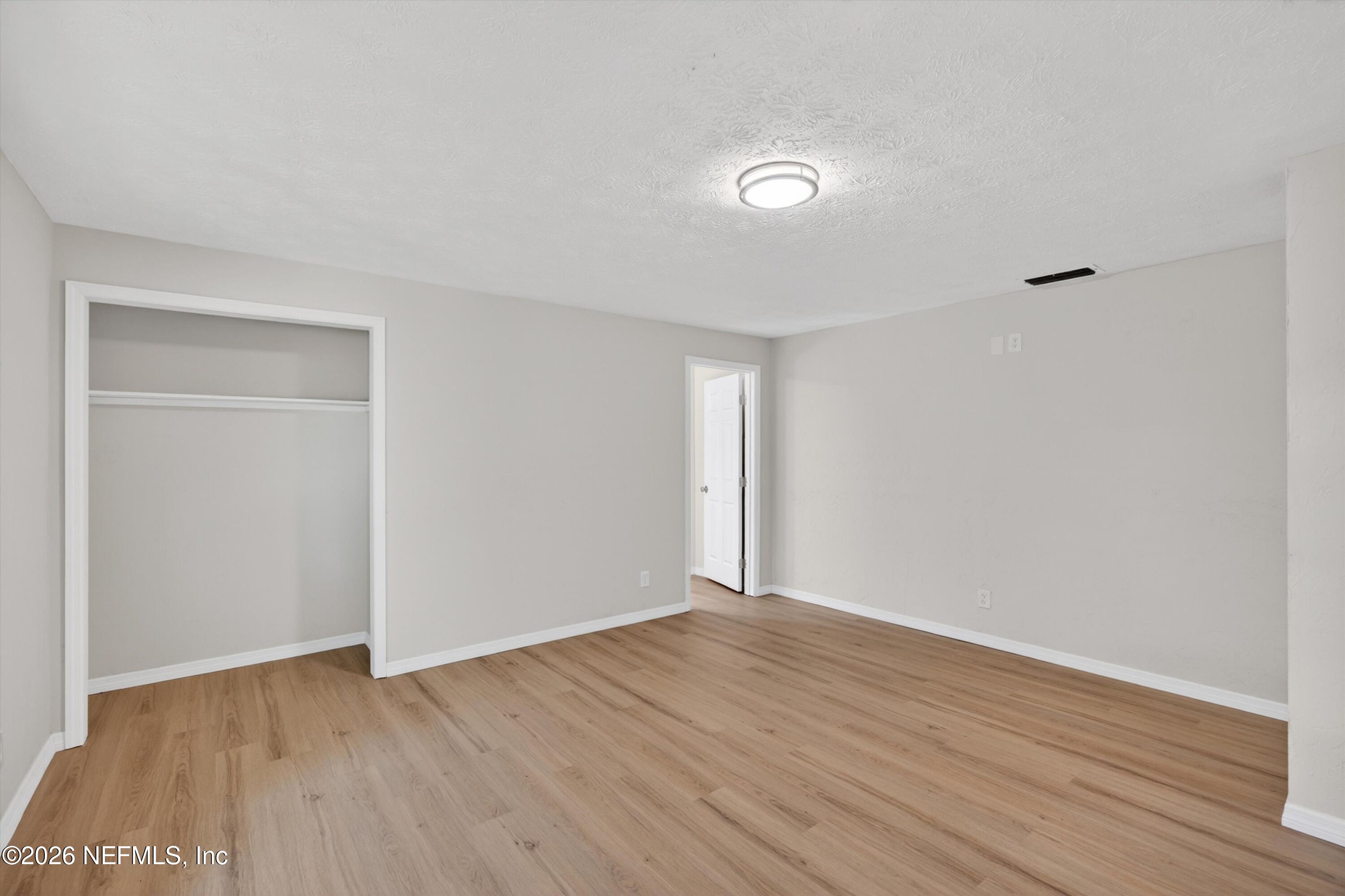 6894 Ridge Street Keystone Heights, FL 32656 - Photo 21 of 40 a view of an empty room with wooden floor and a window