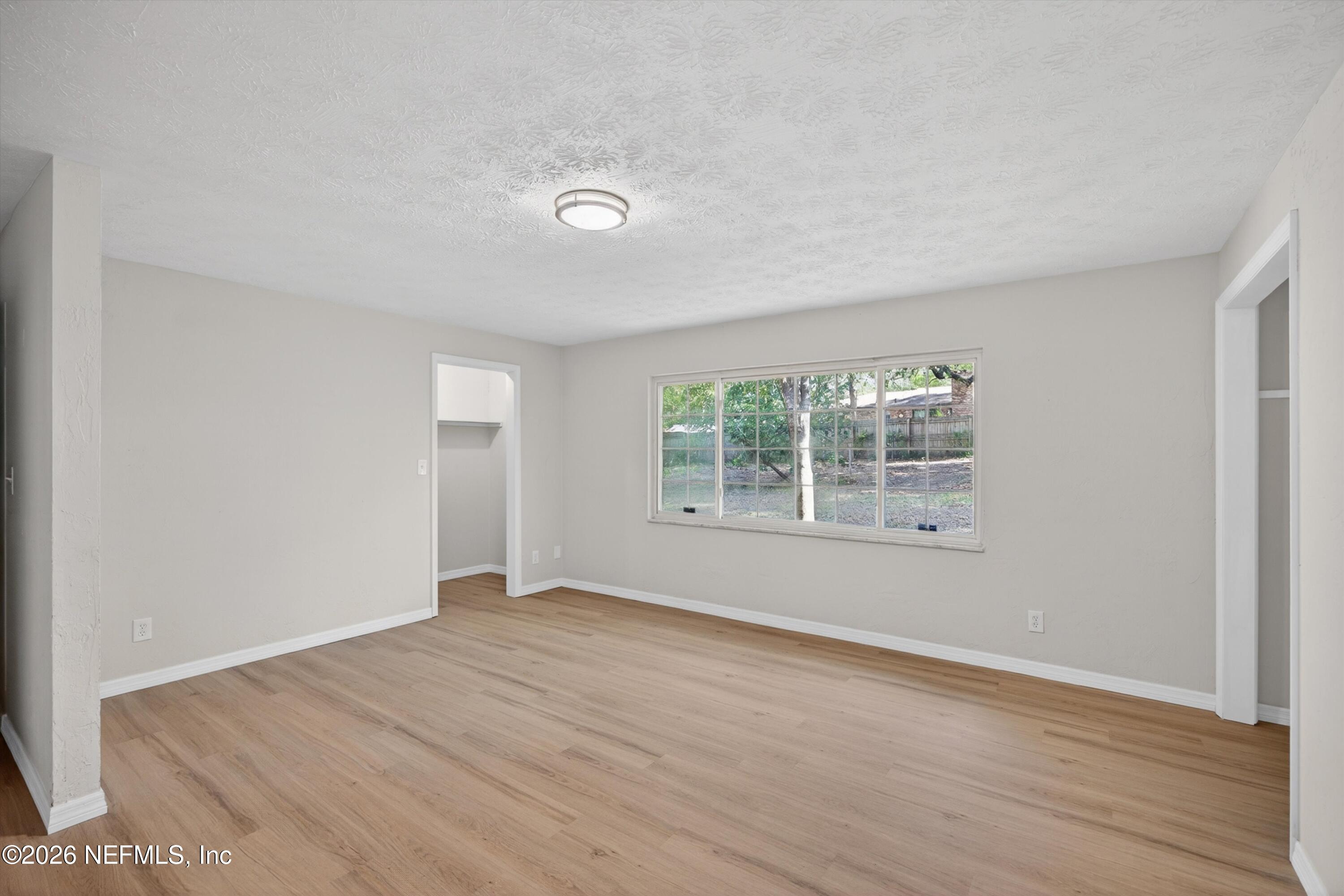 6894 Ridge Street Keystone Heights, FL 32656 - Photo 22 of 40 an empty room with wooden floor and windows