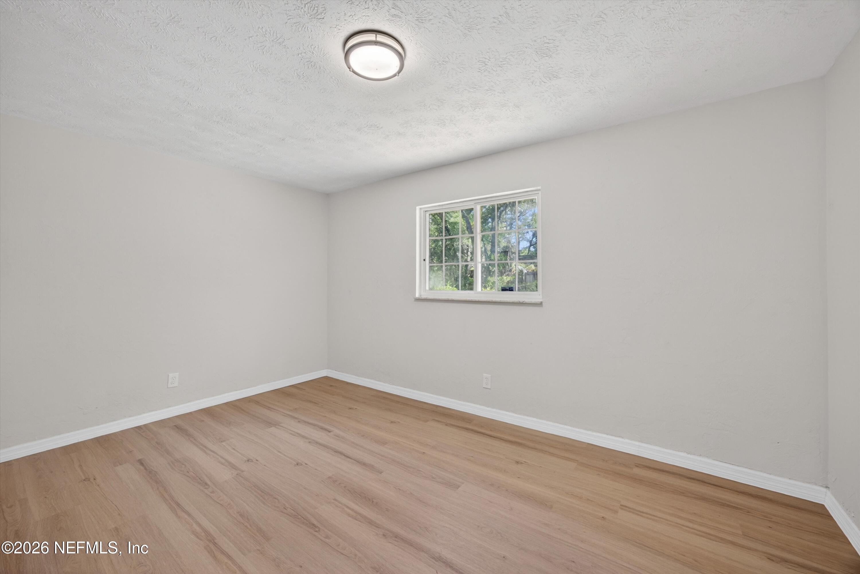 6894 Ridge Street Keystone Heights, FL 32656 - Photo 26 of 40 an empty room with wooden floor and windows