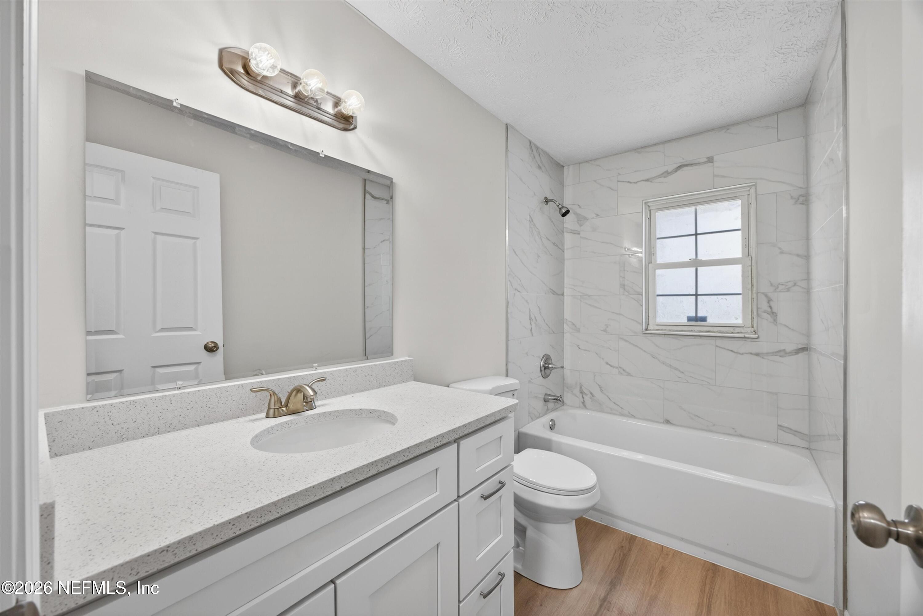 6894 Ridge Street Keystone Heights, FL 32656 - Photo 28 of 40 a bathroom with a granite countertop sink a toilet and shower