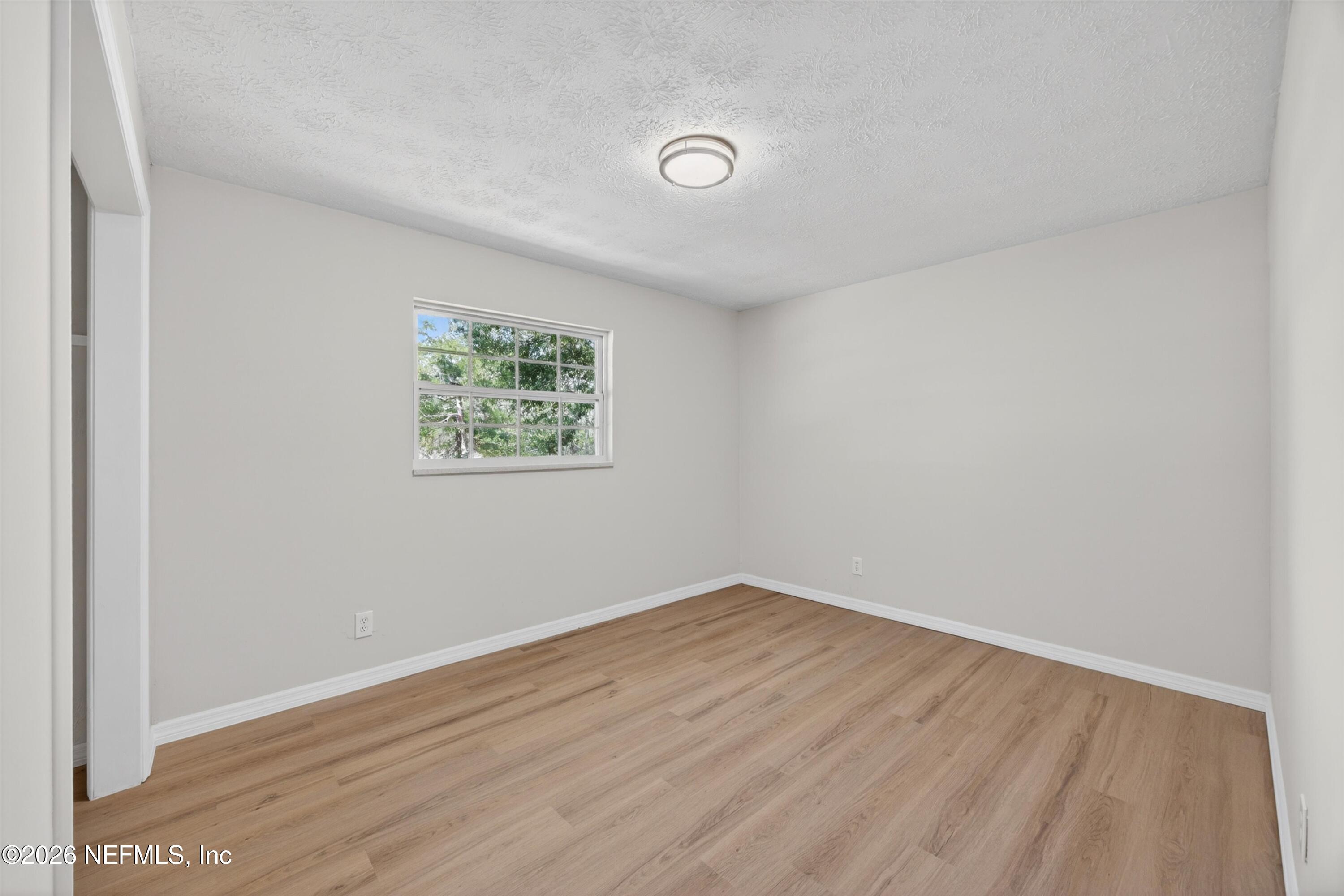 6894 Ridge Street Keystone Heights, FL 32656 - Photo 31 of 40 an empty room with wooden floor and windows