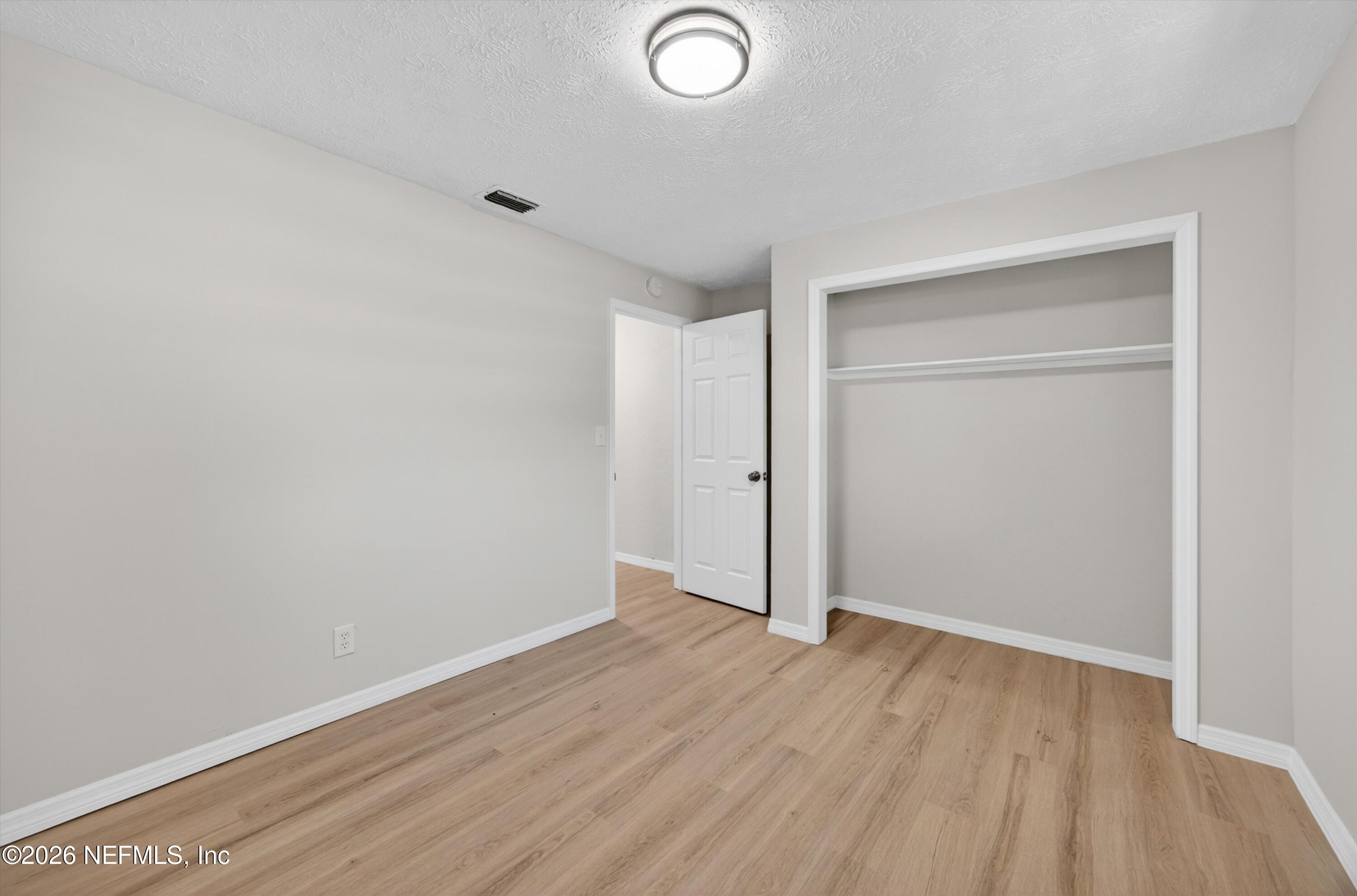 6894 Ridge Street Keystone Heights, FL 32656 - Photo 32 of 40 an empty room with wooden floor and closet