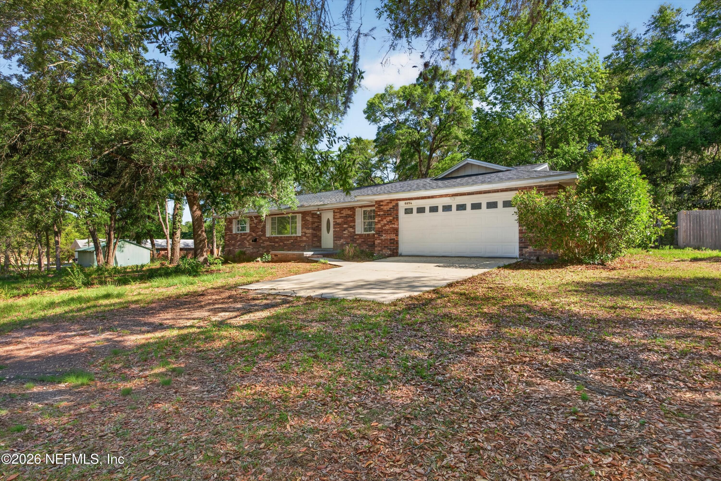 6894 Ridge Street Keystone Heights, FL 32656 - Photo 3 of 40 a front view of a house with a yard and trees