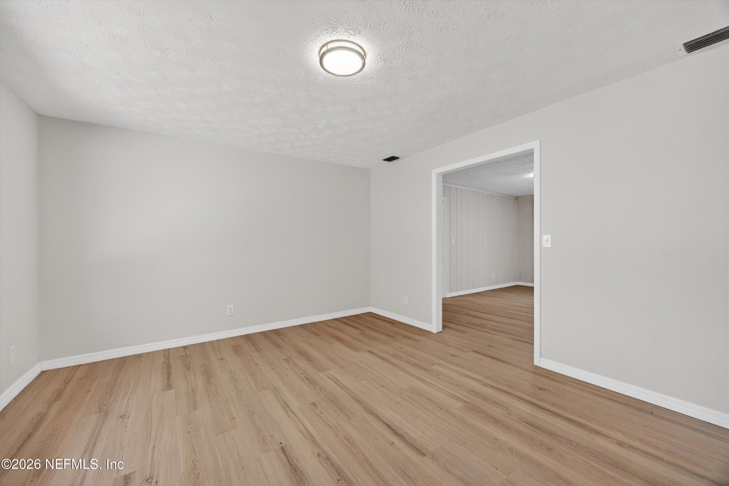 6894 Ridge Street Keystone Heights, FL 32656 - Photo 5 of 40 a view of an empty room with wooden floor and a window