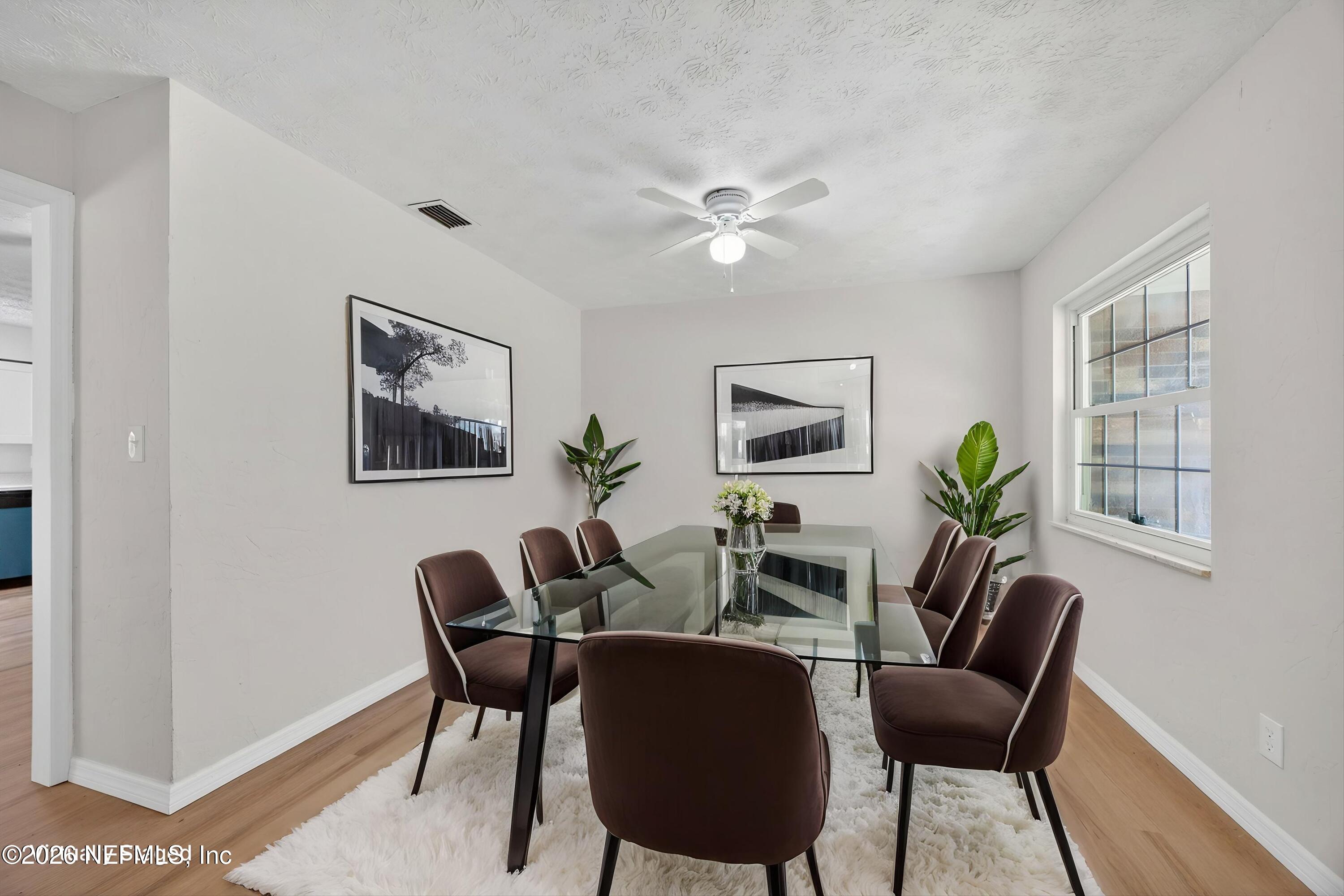 6894 Ridge Street Keystone Heights, FL 32656 - Photo 7 of 40 a view of a dining room with furniture a potted plant and wooden floor