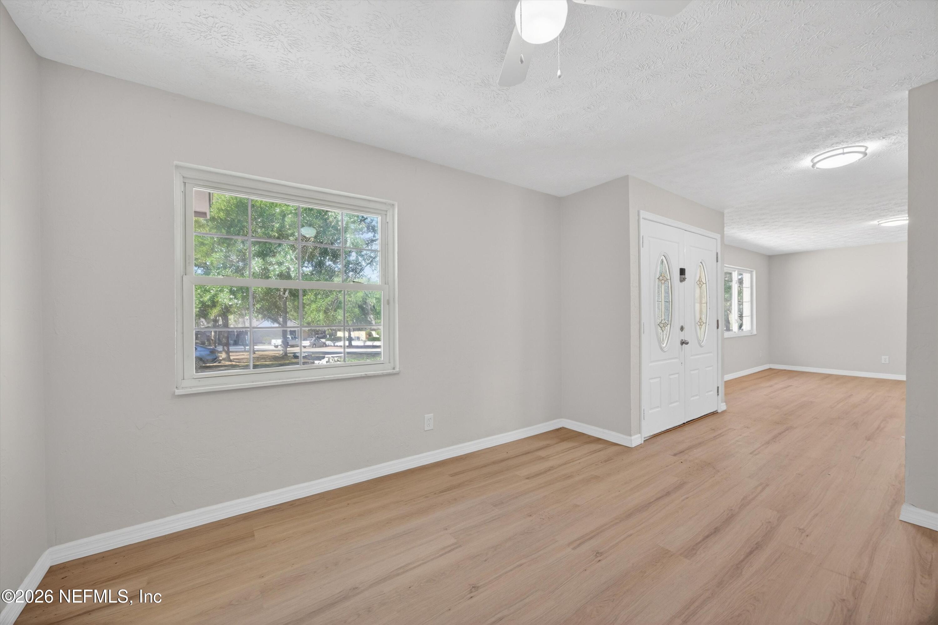 6894 Ridge Street Keystone Heights, FL 32656 - Photo 9 of 40 a view of an empty room with wooden floor and a window
