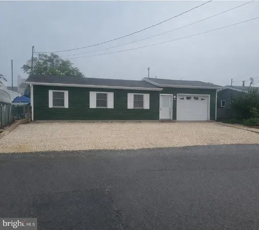 a front view of house with yard and trees in the background