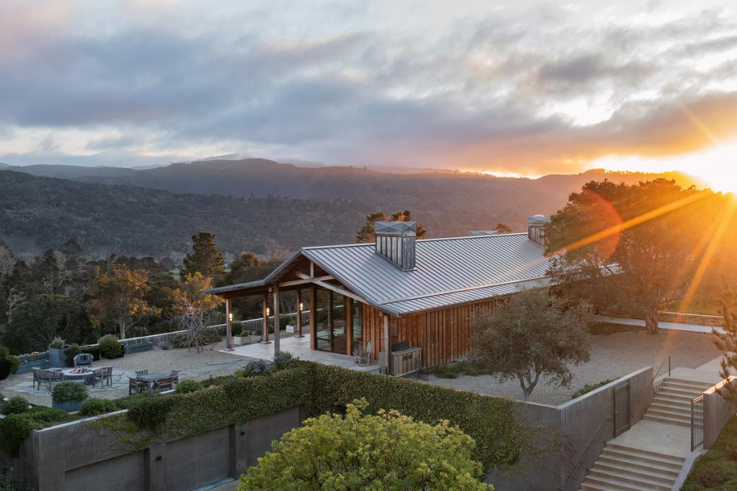 a view of a big house with a big yard and potted plants