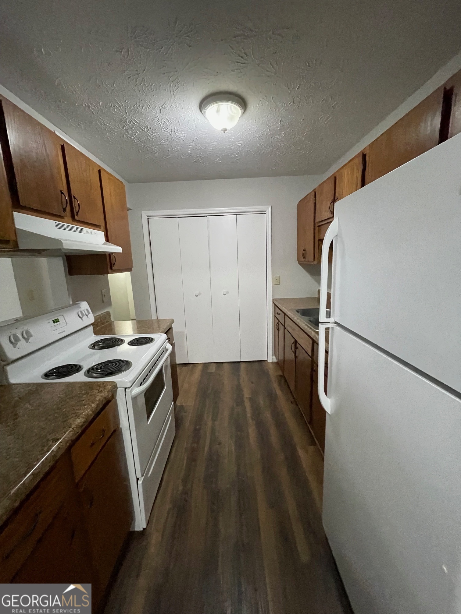 155 Bowen Street, Unit 9 Carrollton, GA 30117 - Photo 13 of 25 a kitchen with a stove a refrigerator and a sink