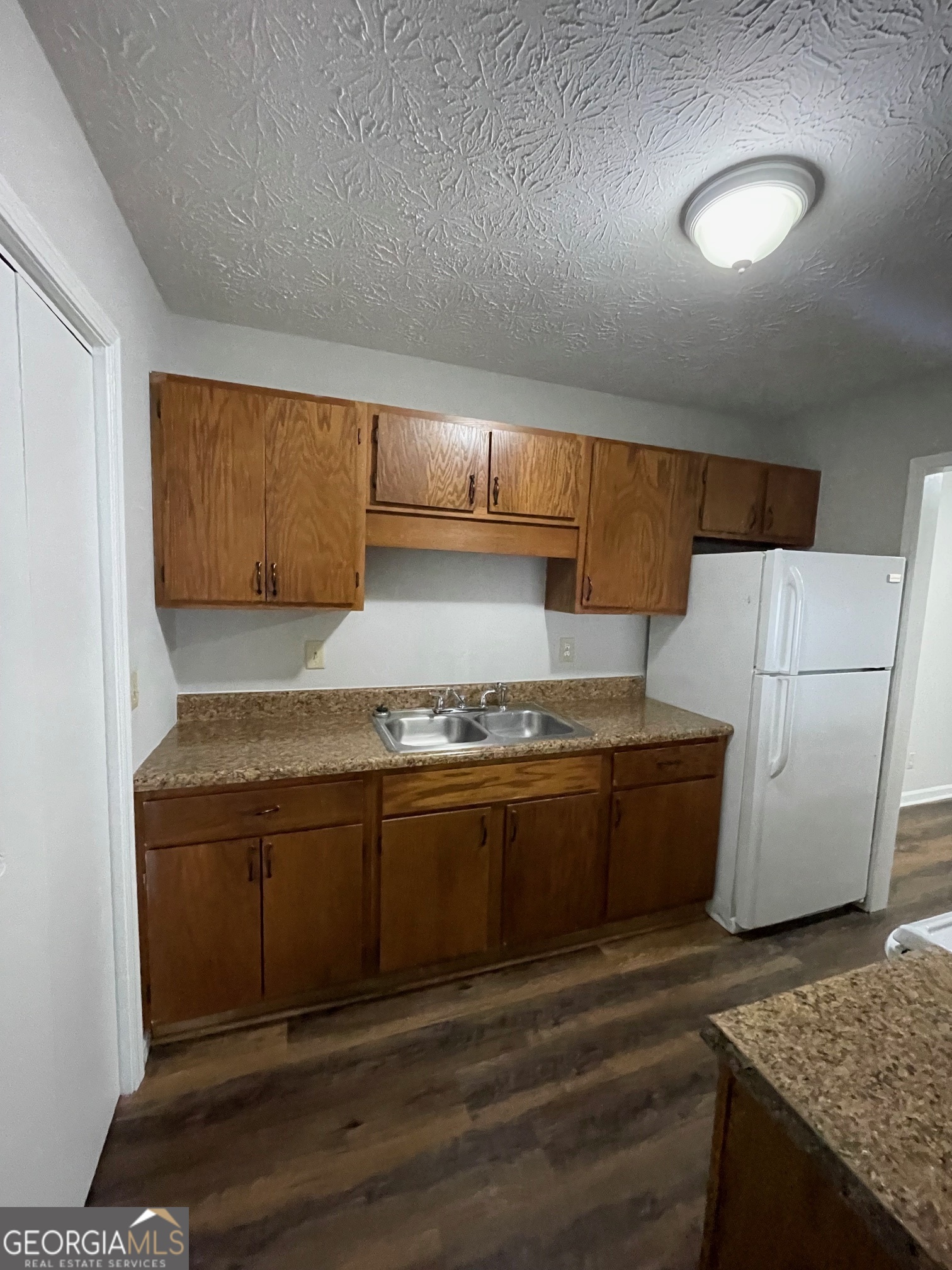155 Bowen Street, Unit 9 Carrollton, GA 30117 - Photo 14 of 25 a kitchen with granite countertop a stove and a refrigerator