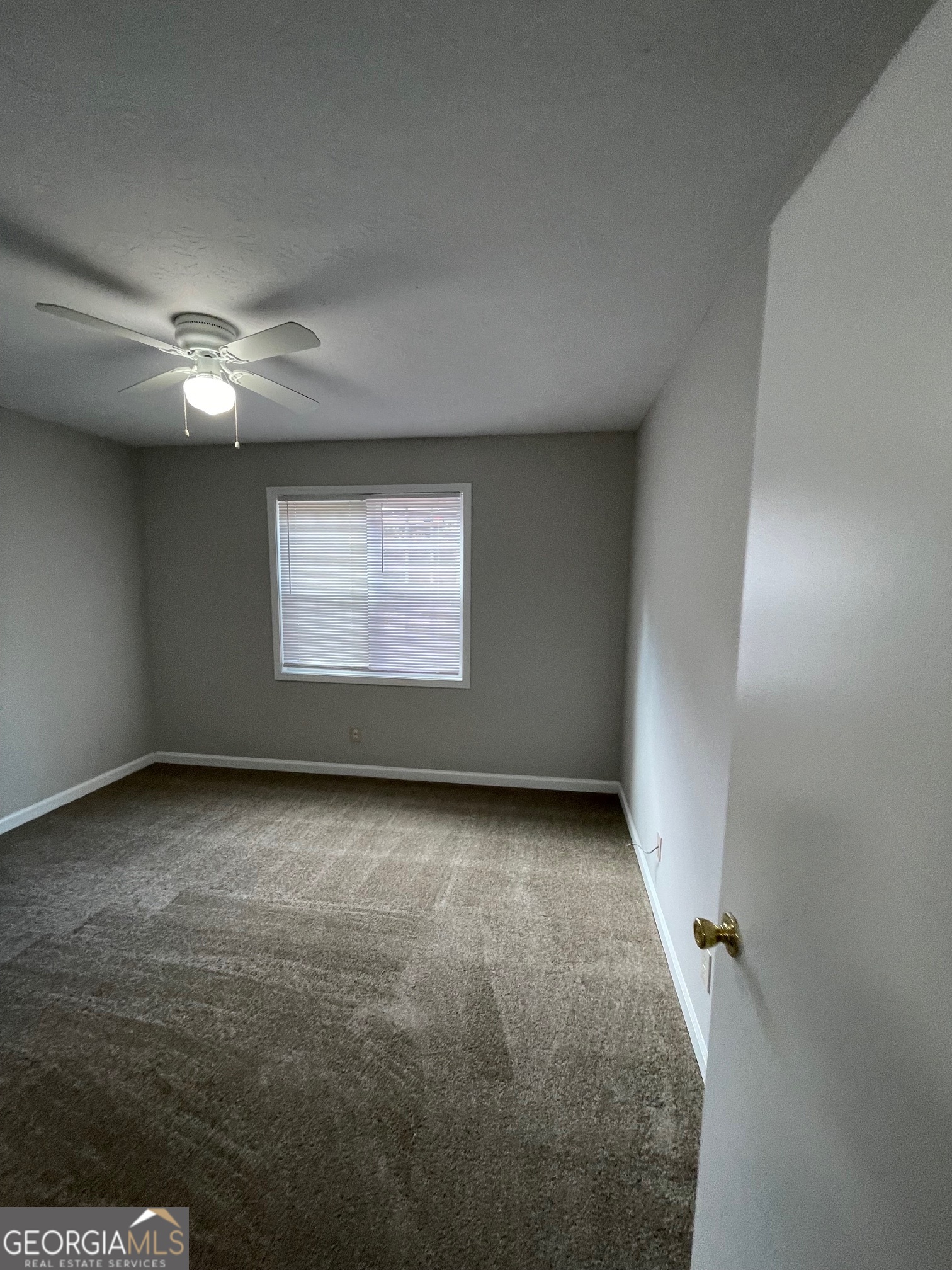 155 Bowen Street, Unit 9 Carrollton, GA 30117 - Photo 16 of 25 an empty room with a ceiling fan and window