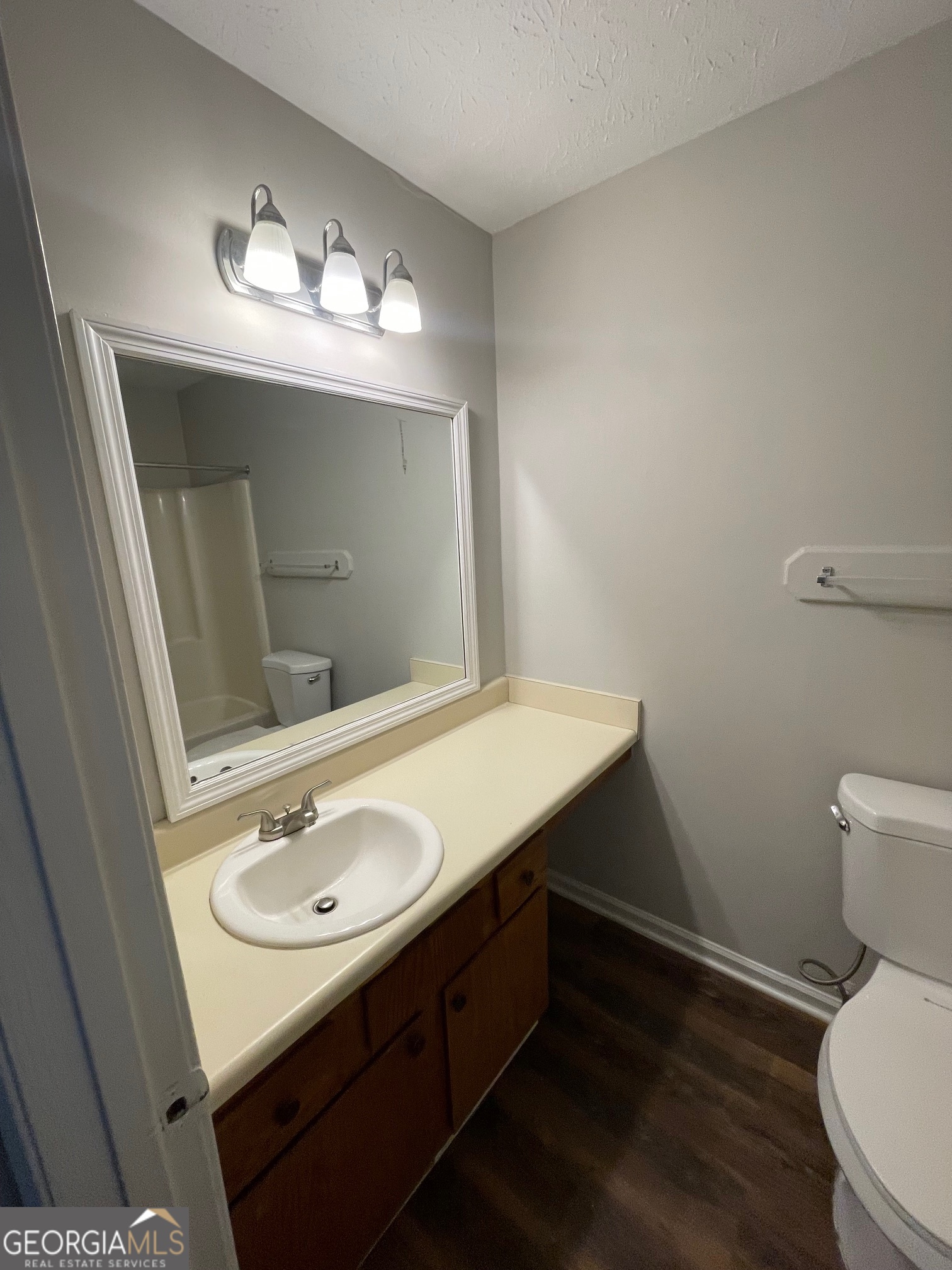 155 Bowen Street, Unit 9 Carrollton, GA 30117 - Photo 24 of 25 a bathroom with a sink a toilet a mirror and vanity