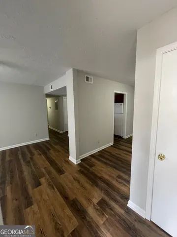 a view of a livingroom with wooden floor and staircase