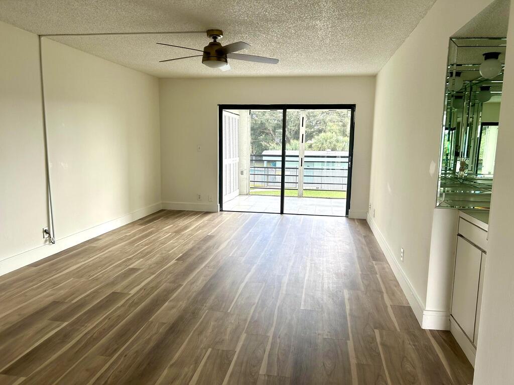 9370 Southwest 8th Street, Unit 202 Boca Raton, FL 33428 - Photo 13 of 46 a view of an empty room with wooden floor and a window