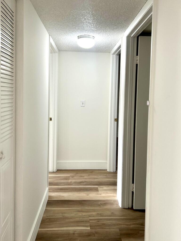 9370 Southwest 8th Street, Unit 202 Boca Raton, FL 33428 - Photo 15 of 46 a view of a livingroom with wooden floor and a bathroom