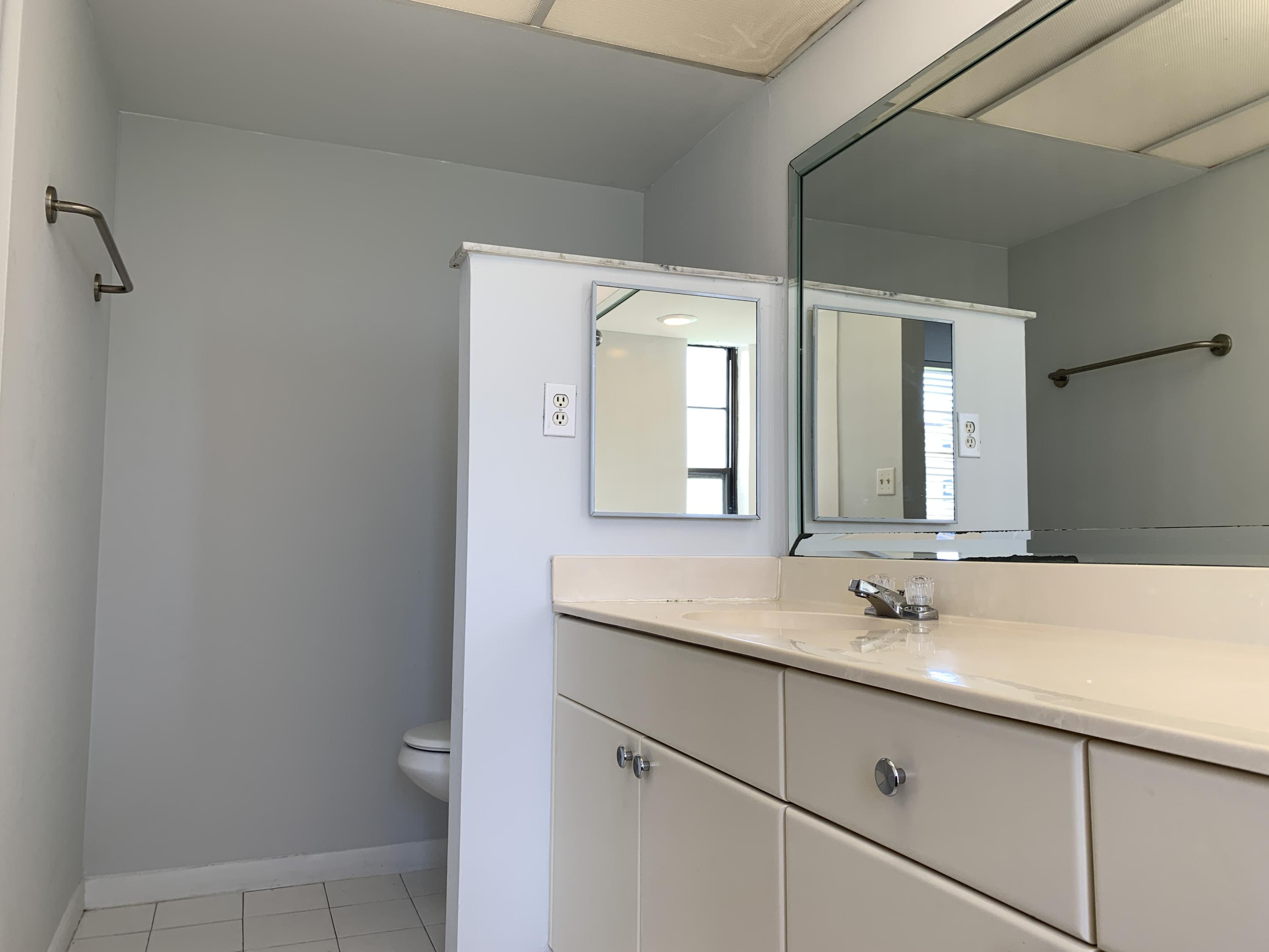 9370 Southwest 8th Street, Unit 202 Boca Raton, FL 33428 - Photo 19 of 46 a bathroom with a sink and a mirror