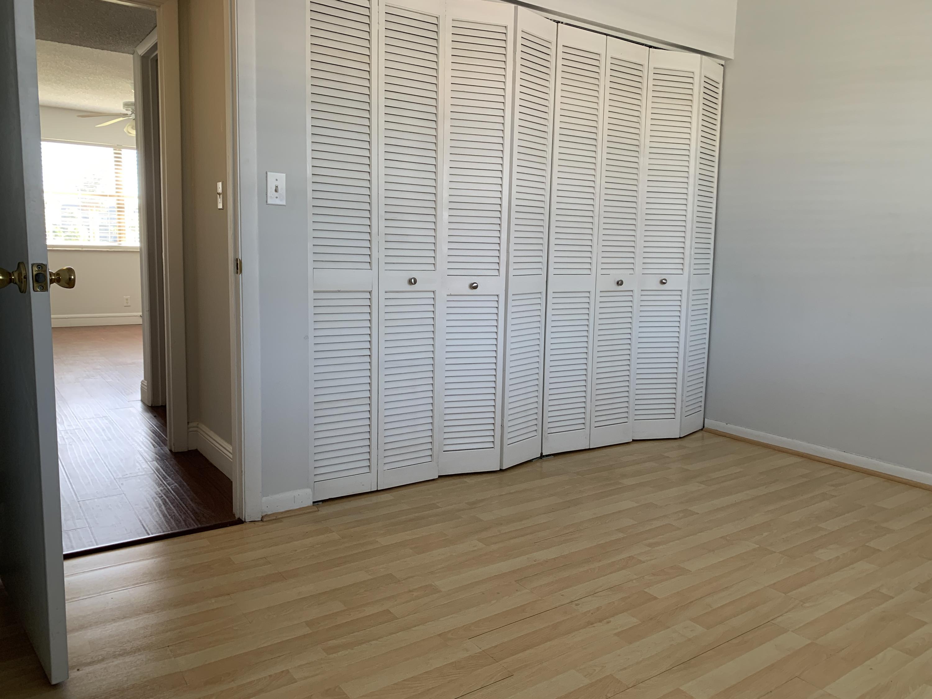 9370 Southwest 8th Street, Unit 202 Boca Raton, FL 33428 - Photo 27 of 46 a view of an empty room with wooden floor and a bathroom